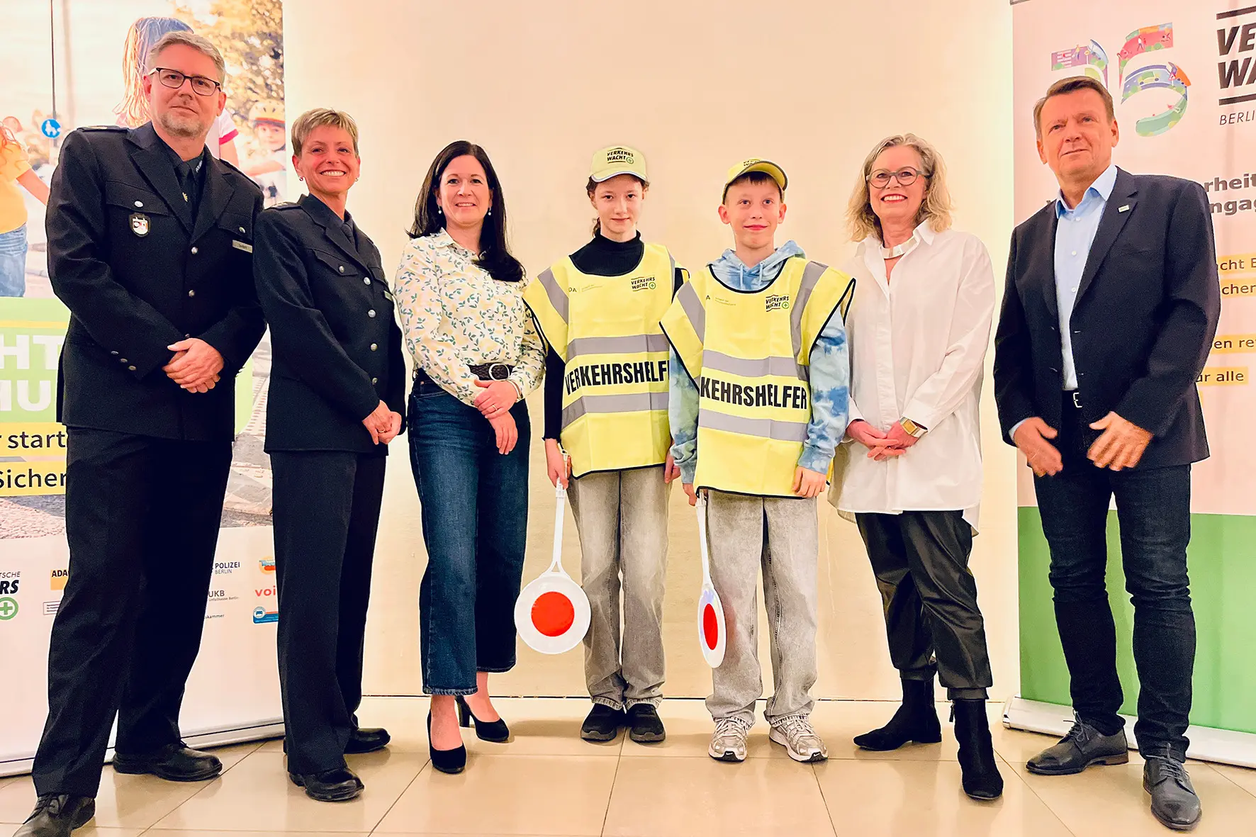 Zwei junge Berliner Verkehrshelfer mit Vertreterinnen und Vertretern von Landesverkehrswacht, Senat und Polizei